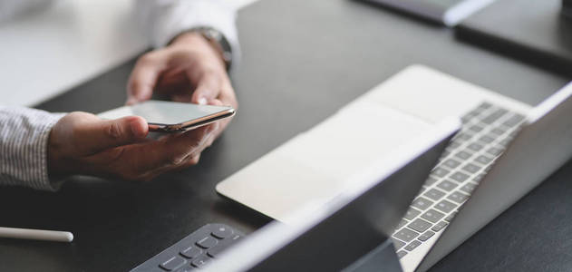 Closeup view of young professional businessman using smartphone