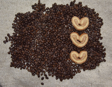 米色背景的咖啡豆和心形饼干图片