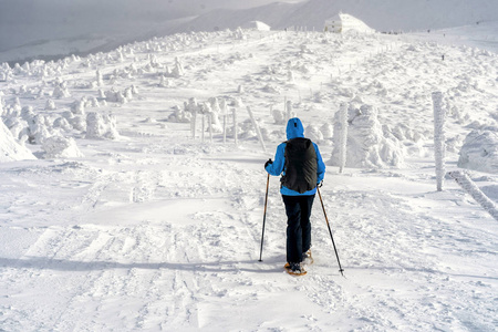冬季运动。背包雪女徒步旅行者