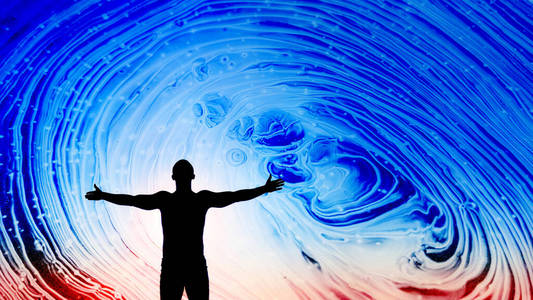 在美丽的蓝红色抽象空间天空下,张开双手的黑色剪影.