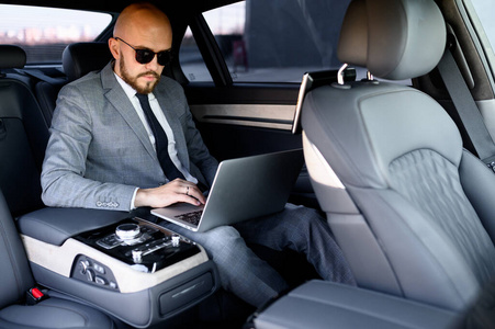 handsome businessman using his mobile phone in a modern car with