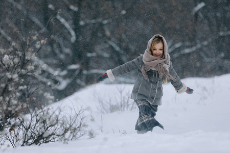 冬天森林里可爱的小女孩。下雪