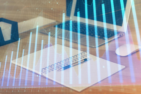 有电脑背景的图表财务信息和工作空间的双重曝光。国际网上交易的概念。