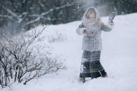 冬天森林里可爱的小女孩。下雪