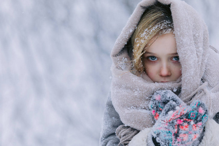 冬天森林里可爱的小女孩。下雪