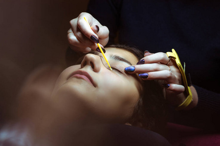 一位年轻女子正在做假睫毛.专业的化妆和美容理念.照片