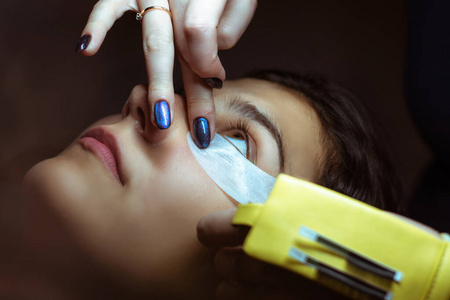 一位年轻女子正在做假睫毛.专业的化妆和美容理念.照片