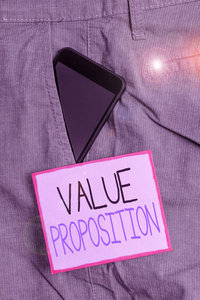 显示价值主张的文字标志。概念照片功能旨在使公司或产品在正式工作裤前口袋靠近便笺纸的口袋内吸引人的智能手机设备。