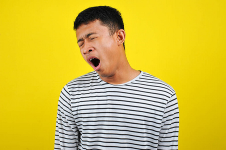 有趣的亚洲男人打哈欠捂住嘴的肖像和表演照片