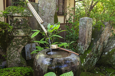 日本寺庙入口处的传统日本竹净化喷泉。