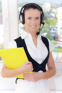女性客户支持电话接线员，在工作场所带耳机