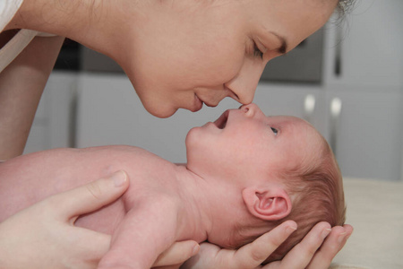 母亲和她的新生婴儿，父母牵着新生儿的手