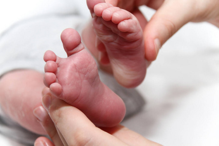 宝宝的脚在妈妈的手上，新生儿的小腿脚