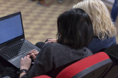 两位商务女性在商务会议上用笔记本电脑工作