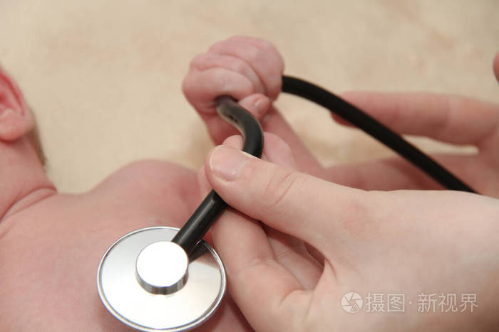 男婴由护士用听诊器做肺部检查