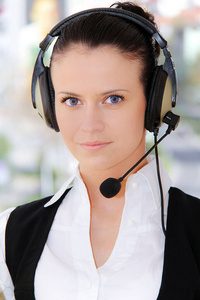 女性客户支持电话接线员，在工作场所带耳机