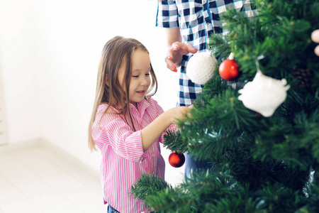 节日，父母和庆祝概念幸福家庭装饰圣诞树在客厅的白色背景