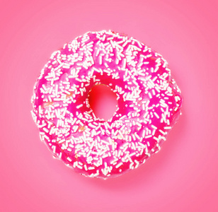 粉红色背景上隔离的甜粉色甜甜圈