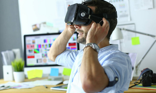 年轻的男性软件程序员在办公室里用3d虚拟现实眼镜测试一款新的应用程序。