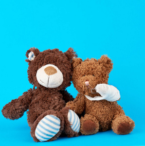 brown teddy bear with rewound white bandage paw 