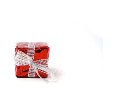 Beautiful red gift box with a silver bow on a white background. 