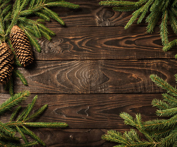 fir branches and cone on dark old wooden background 