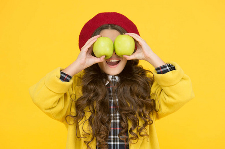 吃苹果有助于学习.小孩拿着黄色背景的苹果.