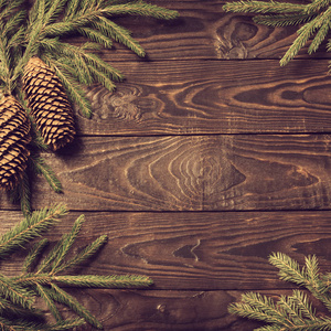 fir branches and cone on dark old wooden background 