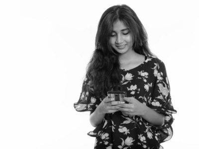 摄影棚拍摄年轻快乐的波斯女人一边用手机微笑