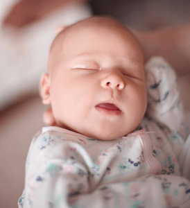 有趣的新生婴儿睡在妈妈的怀里