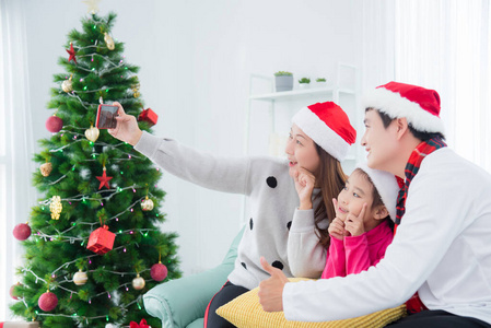 Happy asian family taking their photo by smart phone in room 