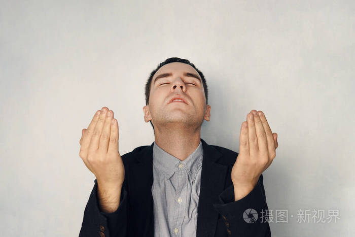 一个穿着西装的专注的男人在沉思商人举起双手祈祷祈