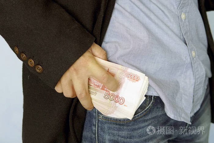 俄罗斯口袋里的钱牛仔裤。5000卢布的。金融的概念。特写。那个人把放在口袋里。薪水。