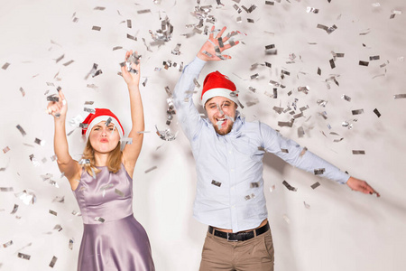 新年圣诞节和派对理念欢快的年轻人在白色背景上洒下五彩纸屑。