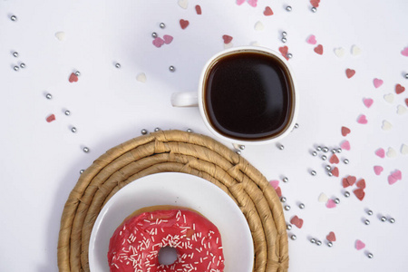 漂亮多汁的甜甜圈，盘子里有咖啡，放在装饰托盘上。白色背景的纸杯蛋糕用于厨房设计。