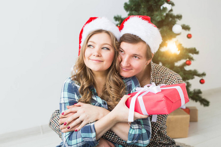 家庭，圣诞节，寒假和人的概念幸福的夫妇拥抱在家中的圣诞树附近