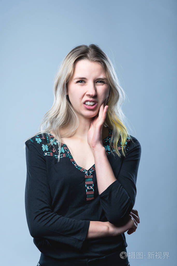 一个女孩的特写肖像在一个孤立的灰色背景上人的面部