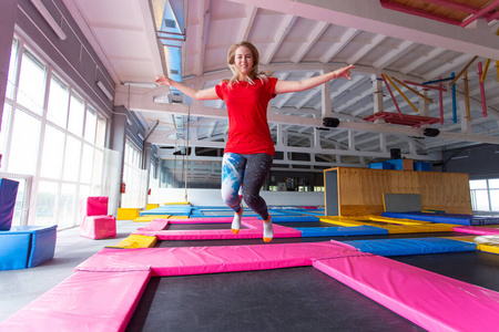 健身娱乐休闲和体育活动理念室内蹦床上跳跃的年轻快乐女性