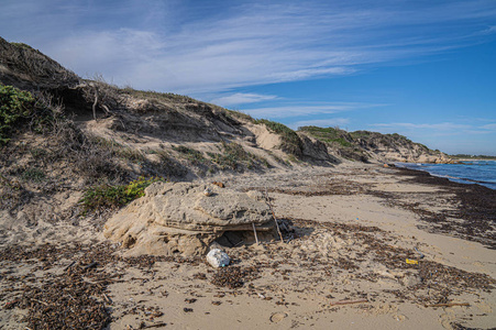 意大利普利亚托雷瓜切托美丽的荒芜海滩在多云的傍晚,在海边的一片