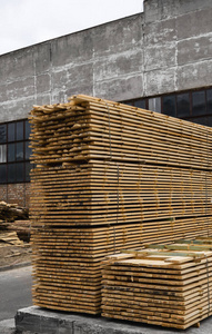 锯木厂里成堆的木板，木板。户外锯木厂上锯木板的仓库。木质毛坯建筑材料的木材堆。工业。
