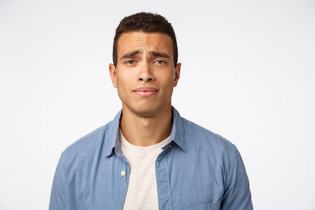 多疑,愁眉苦脸的帅哥愁眉苦脸,有顾虑或忧虑,感到失望,悲伤地站在白色