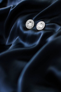 深蓝色丝绸背景奢华钻石耳环，假日gl