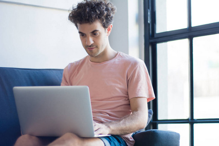 Young man relaxing on the sofa with a laptop 