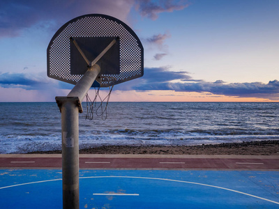 篮球场在海边,日落时天空阴云密布.照片