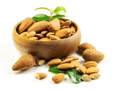 Group of ripe peeled and unpeeled almonds in the wooden bowl on 