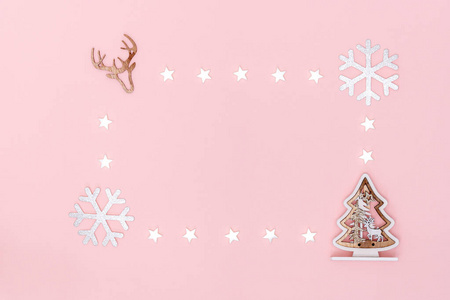 新年和圣诞作文。框架由白色的星星，雪花，圣诞树和鹿的象征在粉彩纸背景。俯视图，平面布置，复制空间