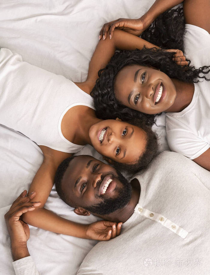 幸福黑人家庭一起躺在床上的俯视图