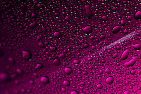水滴落在玻璃上。紫色美丽的抽象背景。宏
