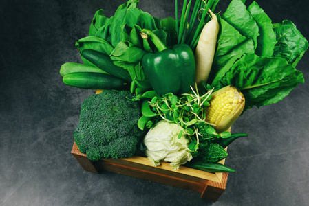 新鲜的绿色水果和绿色蔬菜混合在木箱里