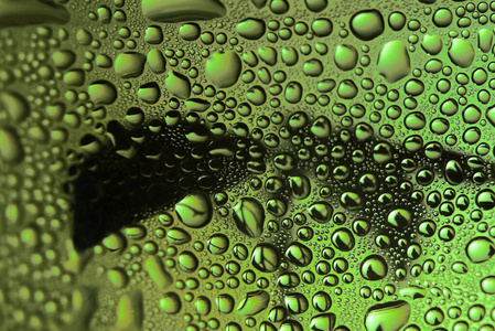 水滴落在玻璃上。绿色美丽抽象的背景。宏